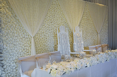 Ivory flower wall, being used as a backdrop to the top table.
